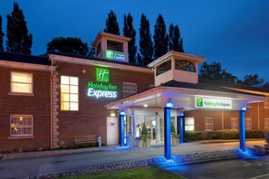 A Holiday Inn Express hotel with a brick facade, a covered entrance, and a parking lot.