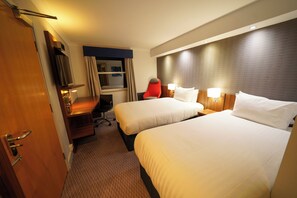 A hotel room with two beds, a desk, a chair, a TV, and a window with curtains. - Holiday Inn Express Leeds East by IHG (Leeds)