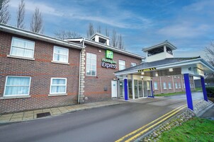 A Holiday Inn Express building with a brick facade, large windows, and a covered entrance area.