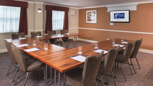 A conference room with a long table, chairs, and a clock on the wall. - Holiday Inn Express Leeds East by IHG (Leeds)