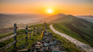 A stone pathway leading uphill with a wooden fence on the left, surrounded by green hills and a clear sky. - Holiday Inn Express Manchester East by IHG (Manchester)