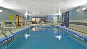 An indoor swimming pool with clear water, a lifeguard chair, and a pool rule sign. - Holiday Inn Express & Suites Milford by IHG (Milford)