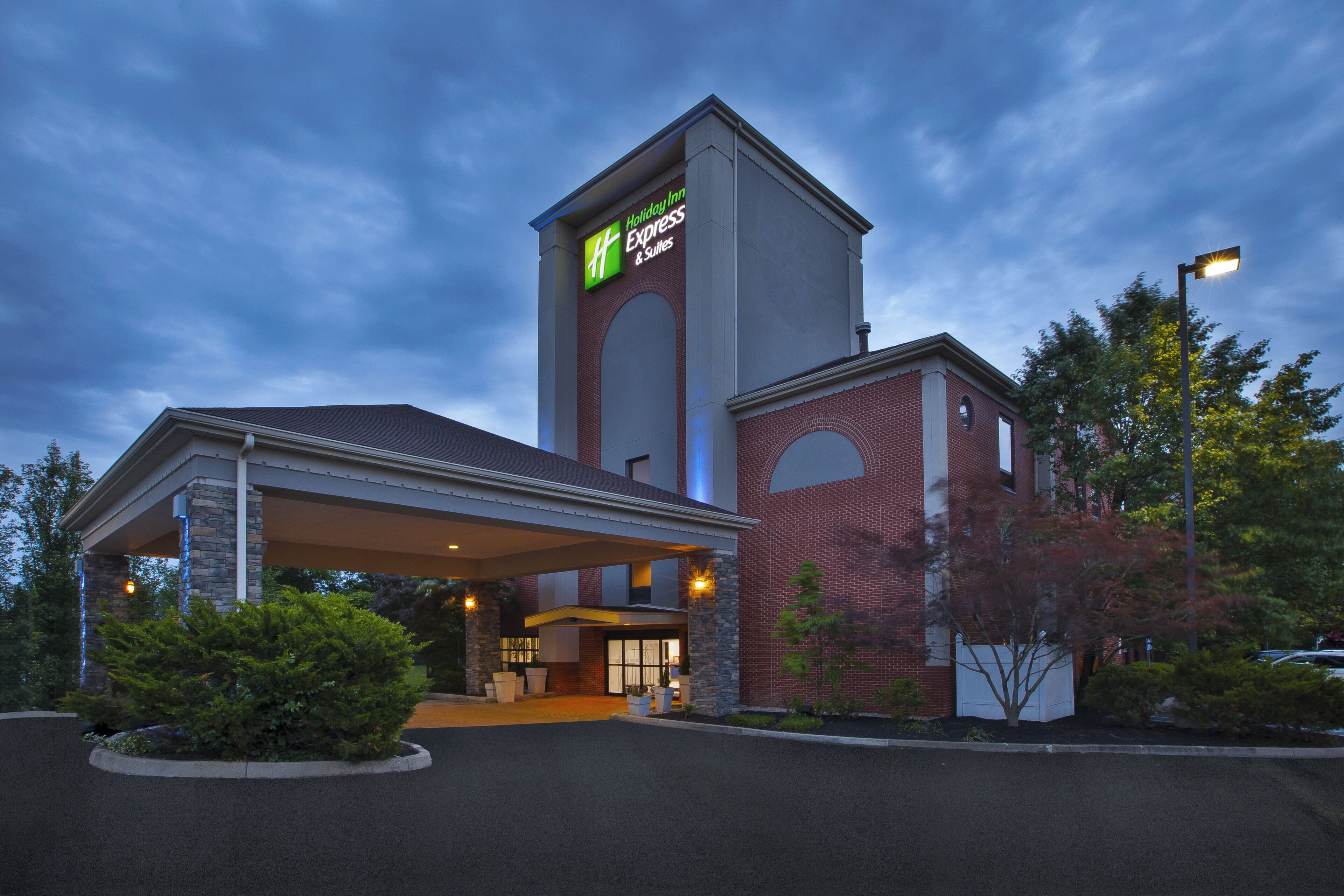 A Holiday Inn Express & Suites hotel with a prominent tower and a covered entrance.