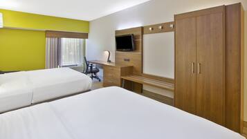 A hotel room with two beds, a desk with a chair, a TV, and a wardrobe.