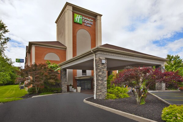 Welcome to Holiday Inn Express & Suites, featuring a charming brick facade and beautifully landscaped gardens.