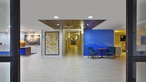 A hotel lobby with a long corridor, a reception desk, and seating area. - Holiday Inn Express & Suites Milford by IHG (Milford)