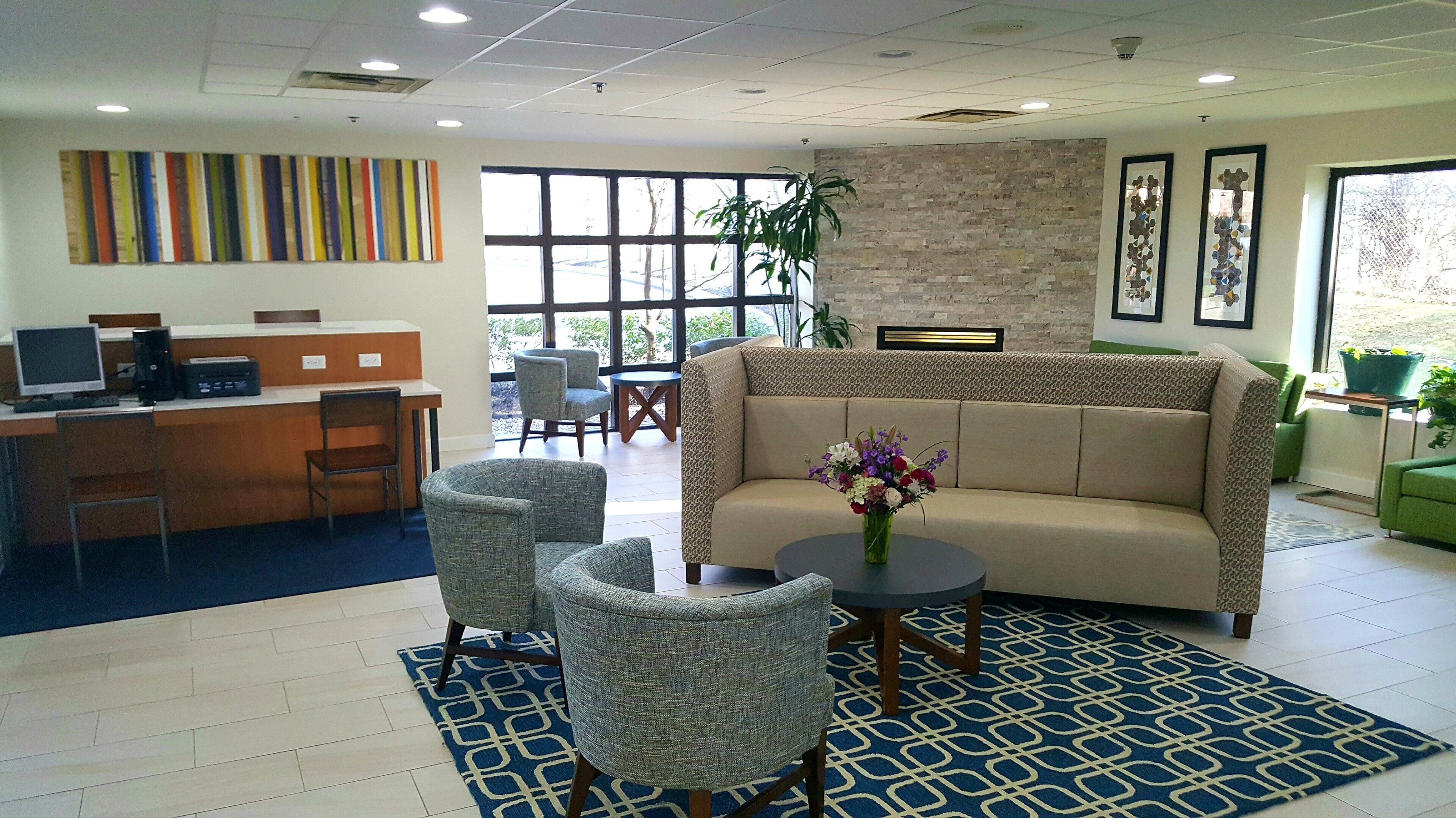 A reception area with a desk, chairs, a sofa, and a coffee table.