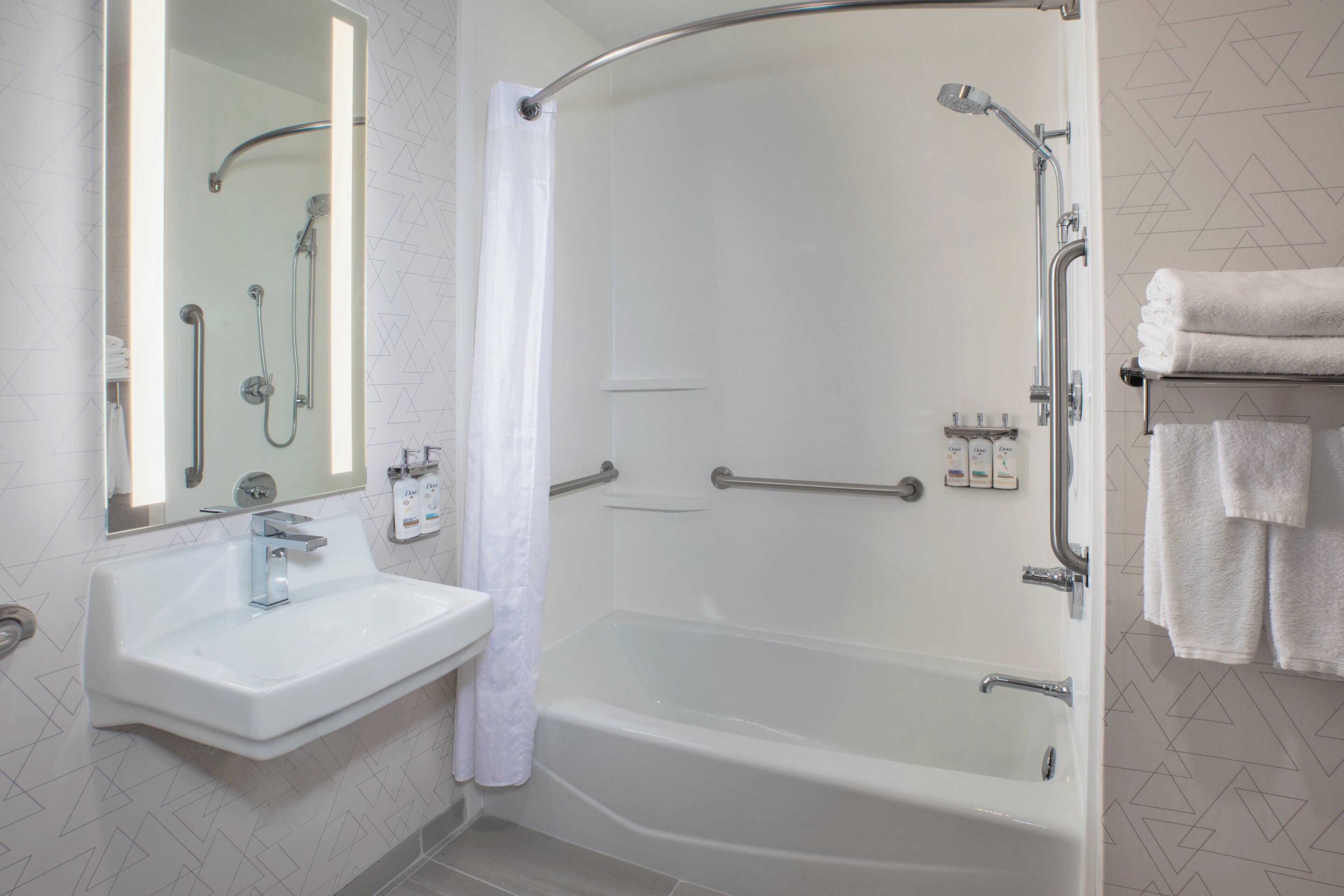 Une salle de bain équipée d’une baignoire, d’un lavabo, d’une douche et d’un porte-serviettes.
