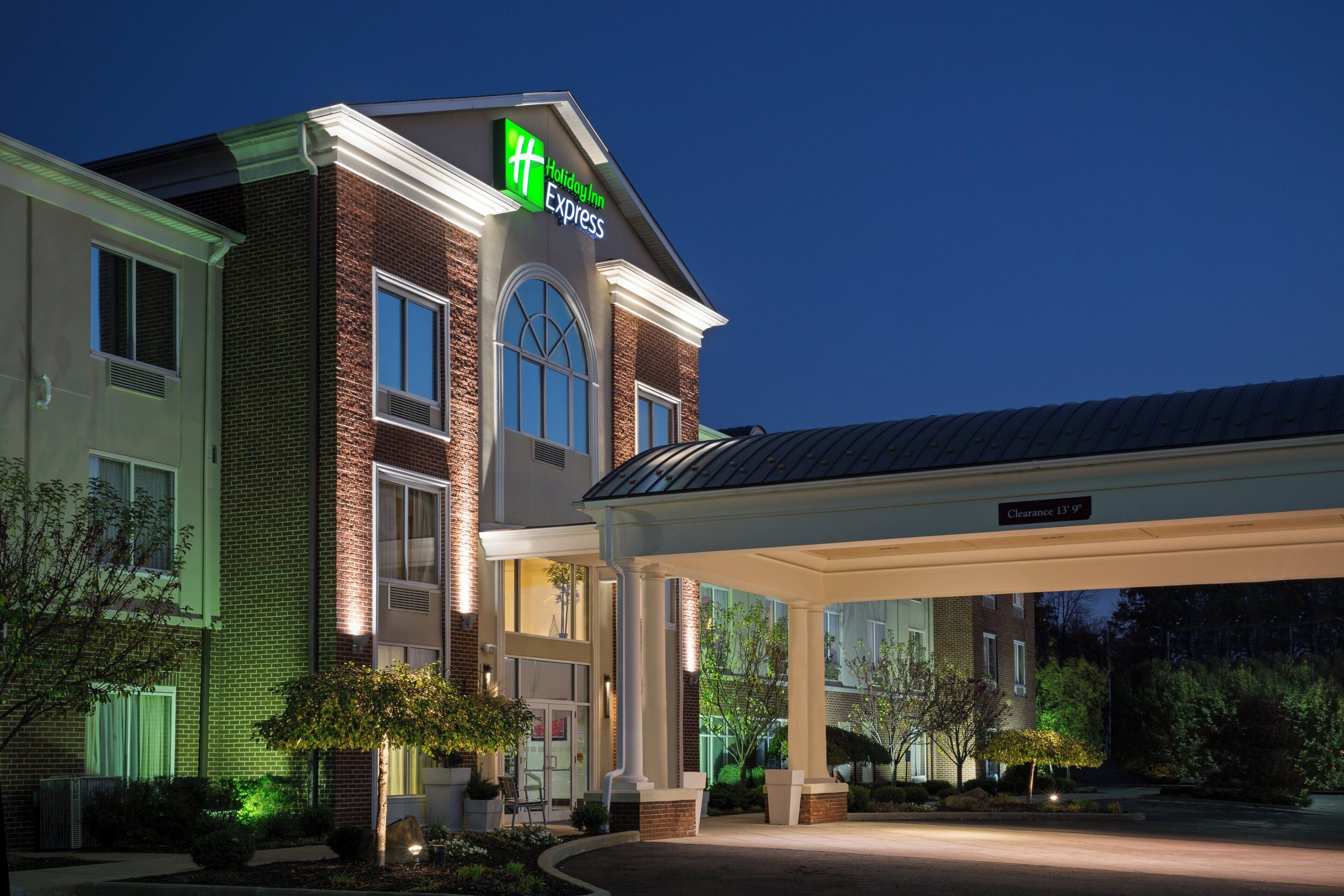 A Holiday Inn Express hotel with a brick facade, large windows, and a covered entrance area.