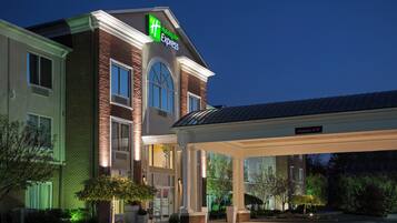 A Holiday Inn Express hotel with a brick facade, large windows, and a covered entrance area.