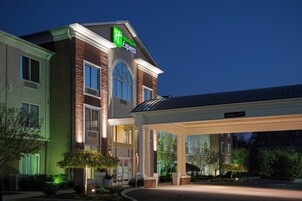 Un hotel Holiday Inn Express con fachada de ladrillo, ventanas amplias y una zona de entrada cubierta.