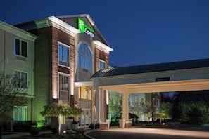 A Holiday Inn Express hotel with a brick facade, large windows, and a covered entrance area.