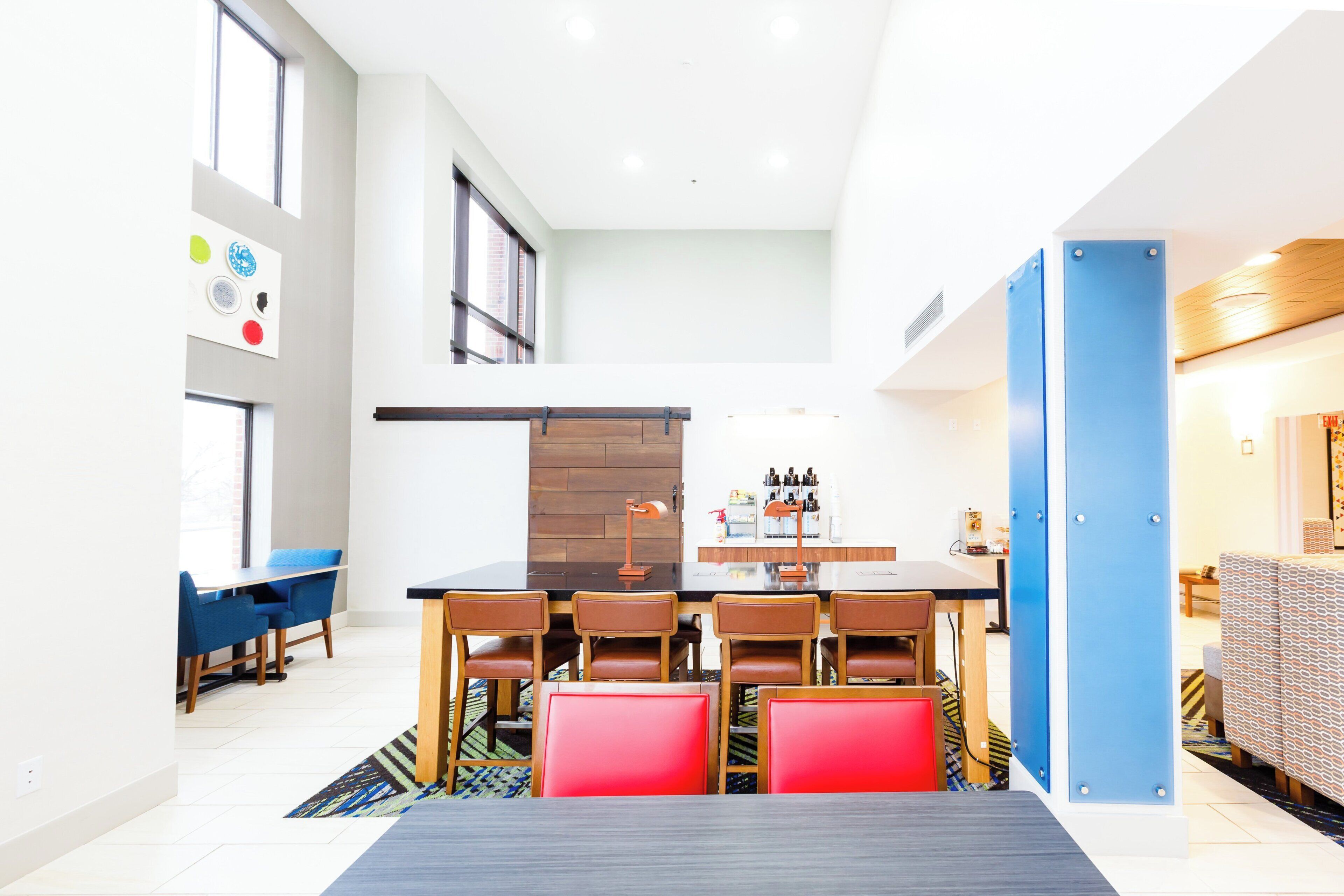 Un comedor moderno con una mesa larga, varias sillas y una estación de café.