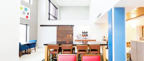 Un comedor moderno con una mesa larga, varias sillas y una estación de café.