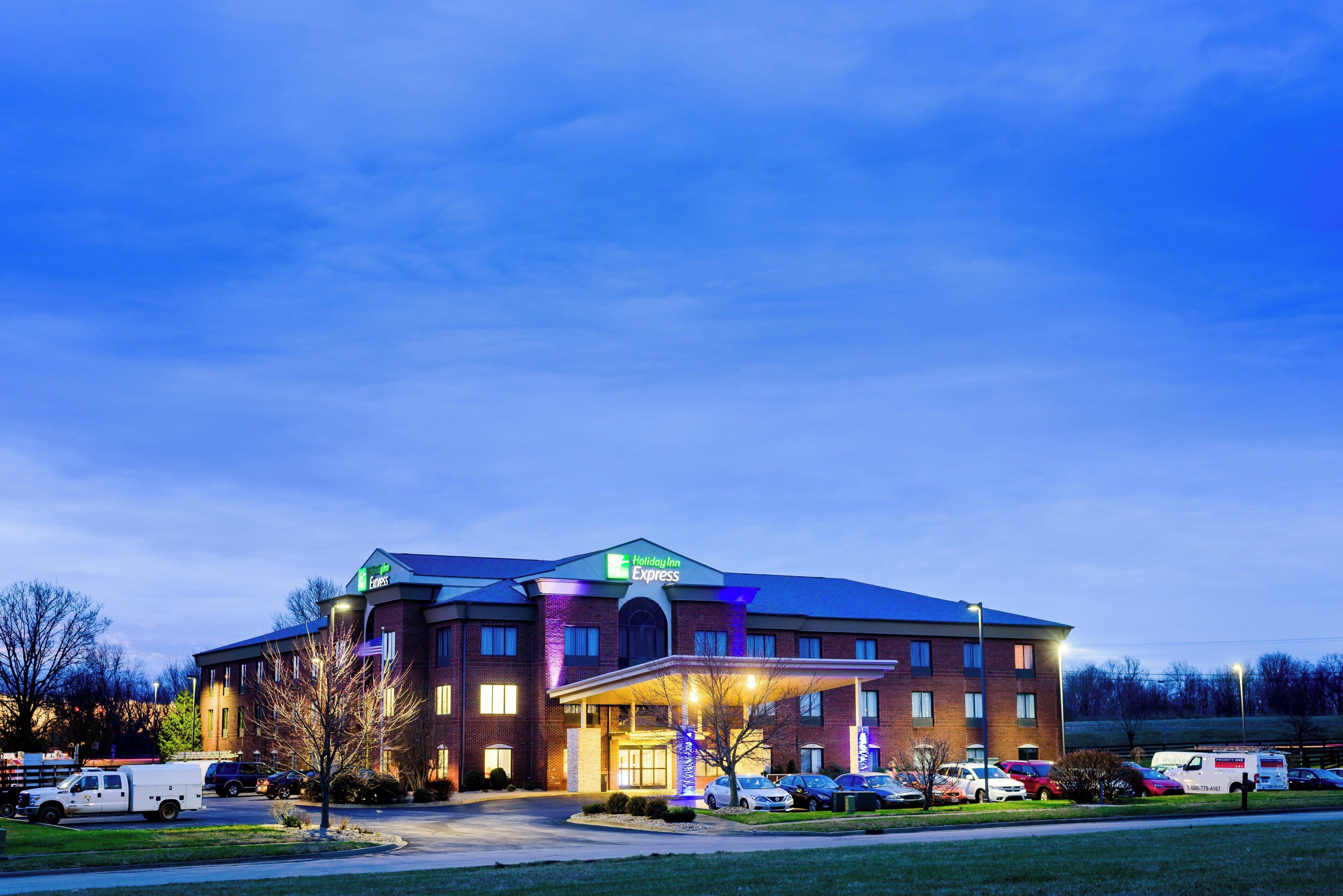 A Holiday Inn Express hotel with a brick facade, multiple parking spaces, and a well-lit entrance.
