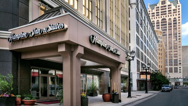 L’extérieur de l’hôtel Hampton Inn & Suites se distingue par sa façade moderne, ses grandes fenêtres et son entrée imposante.
