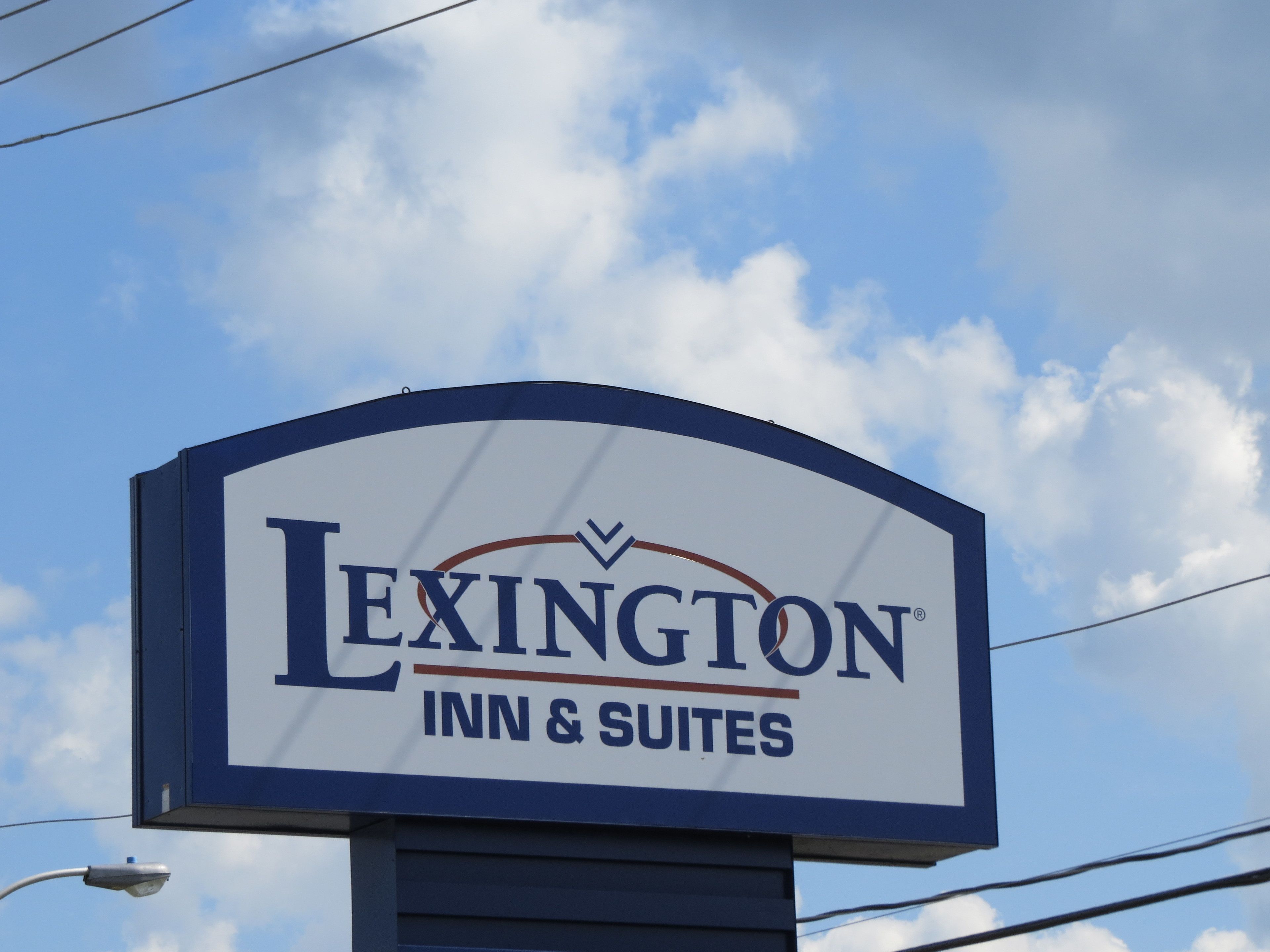 Señal de Lexington Inn & Suites, con un cielo despejado al fondo.