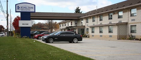 Un hôtel Lexington Inn & Suites doté d’un parking, d’une enseigne et d’un bâtiment avec de nombreuses fenêtres et un toit plat.