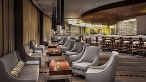 A modern hotel lobby with sofas, armchairs, and a bar area. - Hyatt Regency Pittsburgh International Airport (Pittsburgh)