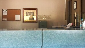 A reception area with a reception desk, a bulletin board, a framed picture, and a green filing cabinet.