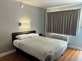 Tabla de planchar con plancha, ropa de cama y despertador