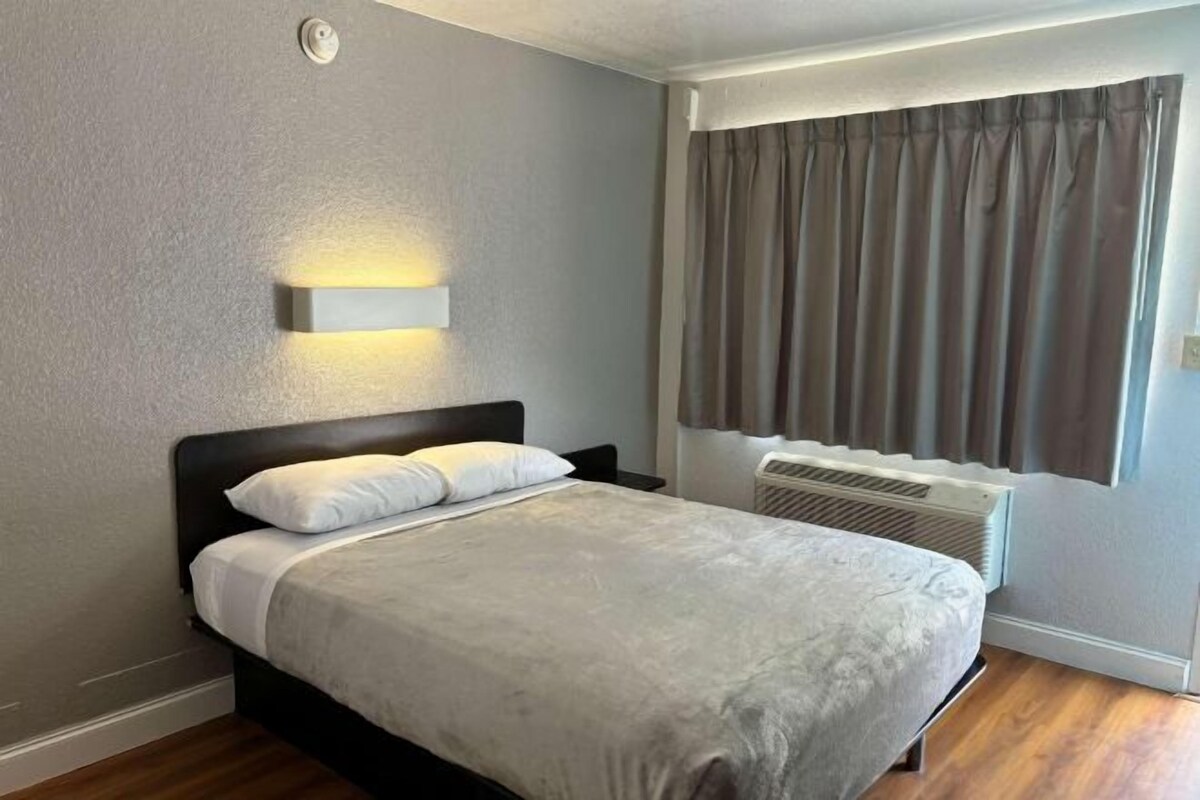 Tabla de planchar con plancha, despertador y ropa de cama 