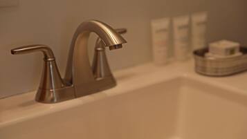 A bathroom sink with a modern faucet and a soap dish.