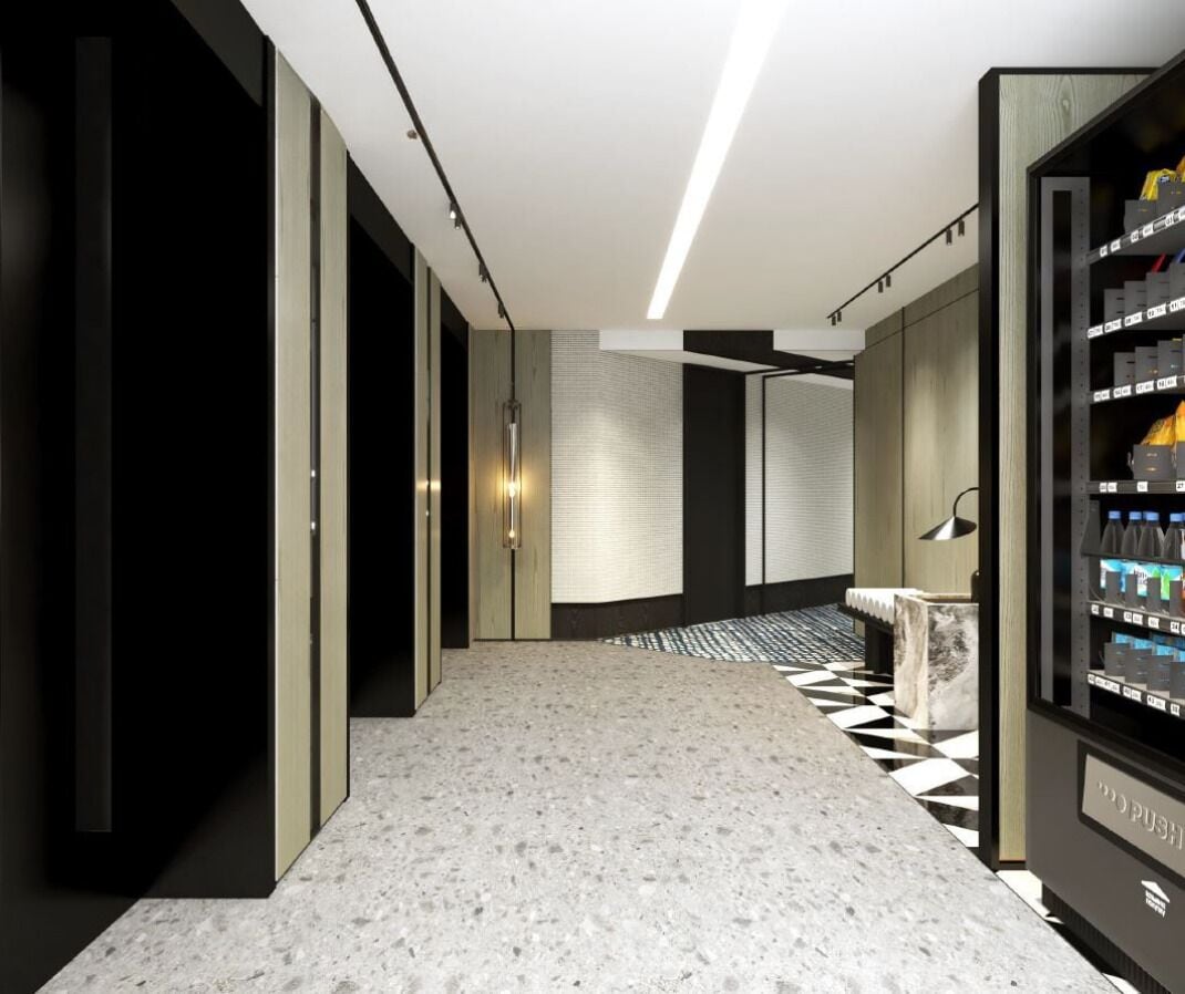 A modern hotel lobby with a marble floor, a vending machine, and a seating area.