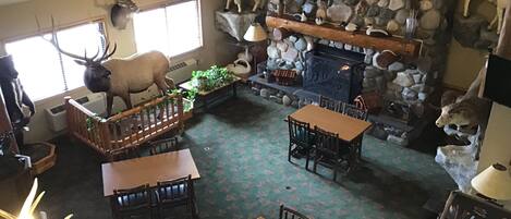 Un interior acogedor con chimenea de piedra, muebles de madera y trofeos de animales colgados.