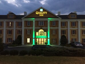 A large hotel with a prominent "Quality Inn" sign, multiple windows, and a well-lit entrance.