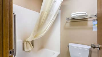 Un baño con cortina de ducha, bañera, inodoro y perchero.