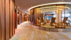 Un lobby de hotel moderno con una zona de estar curva, paneles de madera y suelo de baldosas.