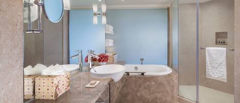 A modern bathroom with a large mirror, two sinks, a bathtub, and a glass shower enclosure.