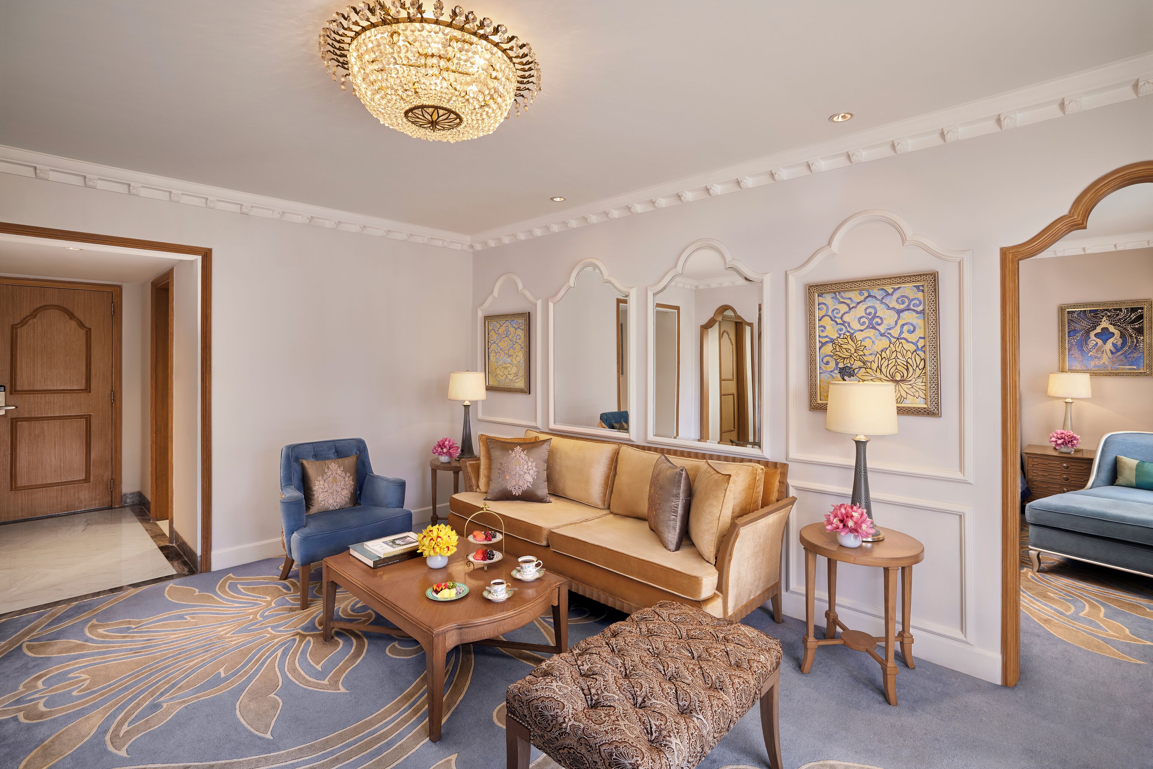 Uma sala de estar bem decorada com sofá, poltronas, mesa de centro e tapete decorativo.