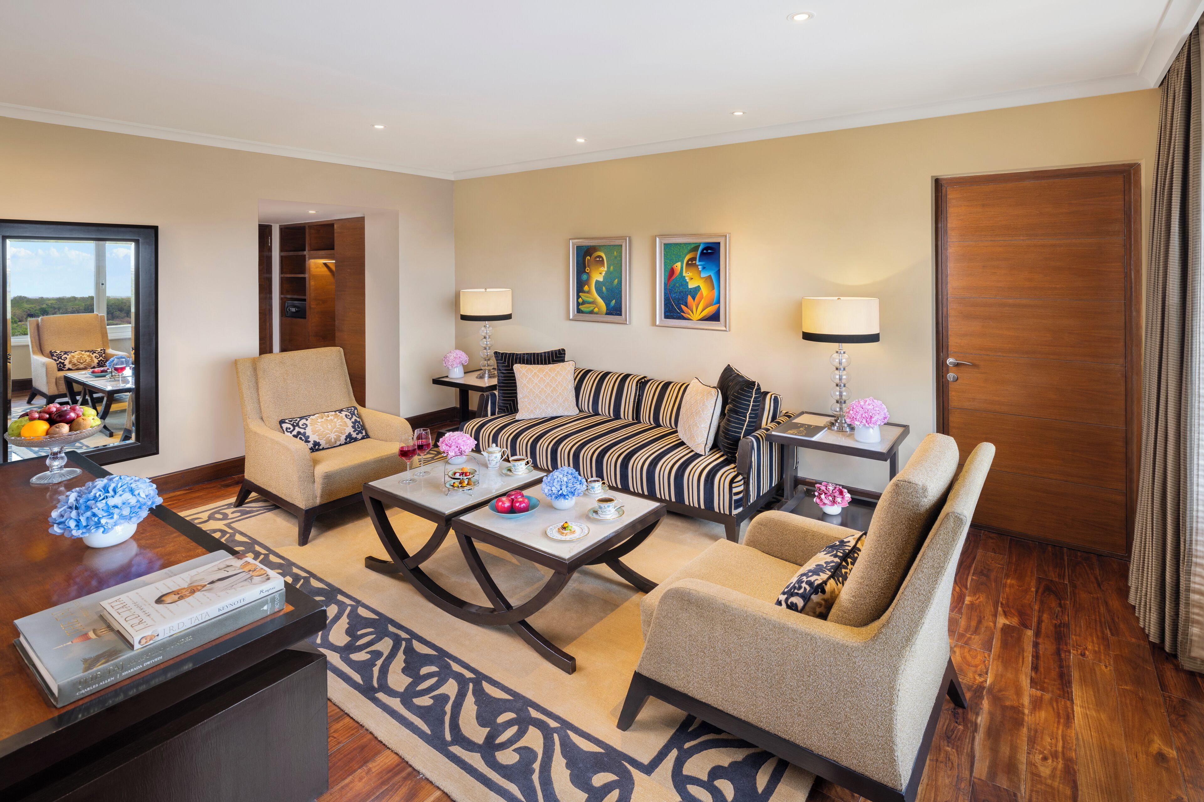 Uma sala de estar moderna com sofá, poltronas, mesa de centro e mesa de jantar decorada.