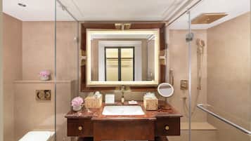 A modern bathroom with a large mirror, a sink, and a shower.