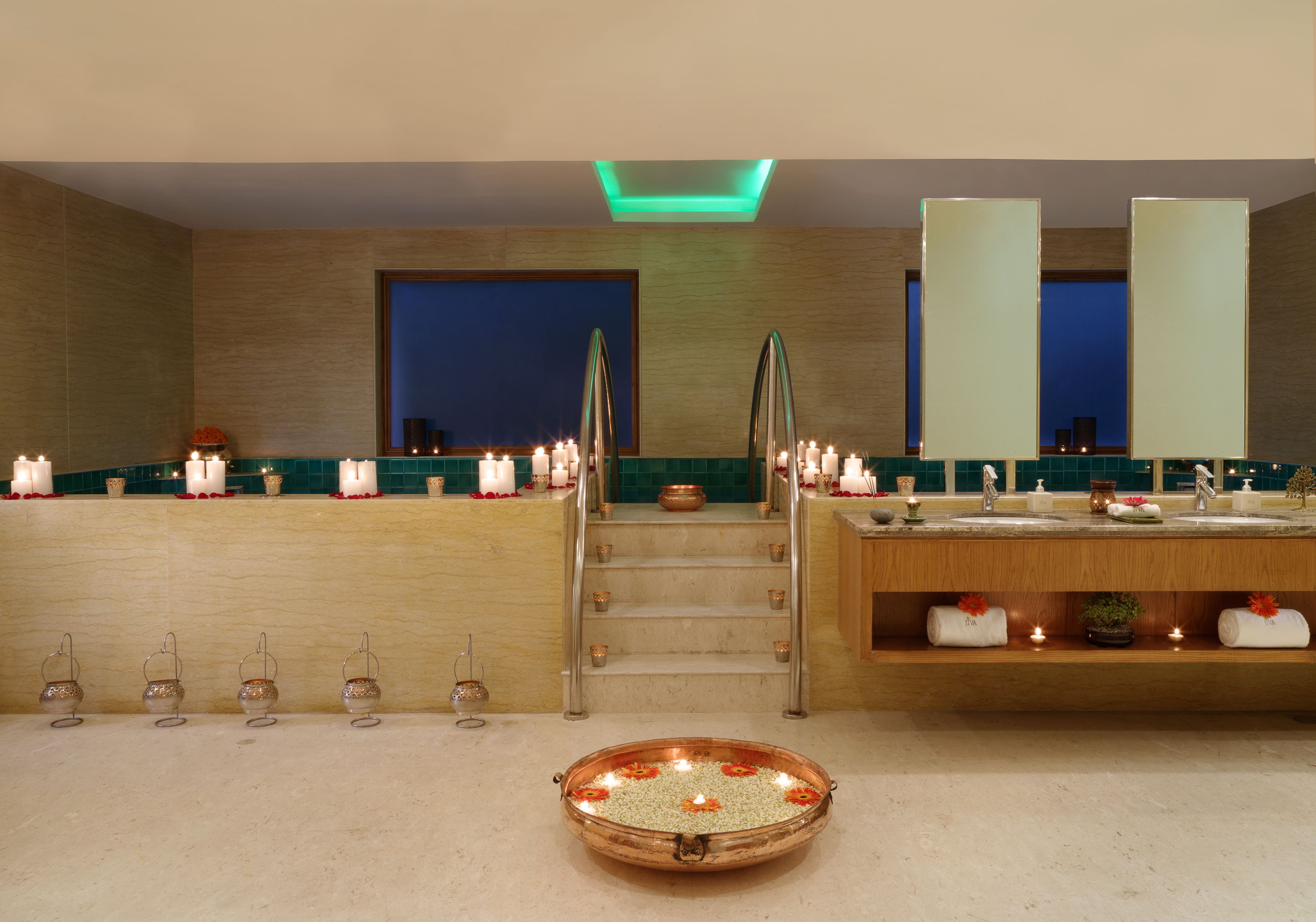 A modern bathroom with a wooden vanity, a large mirror, and a central staircase.