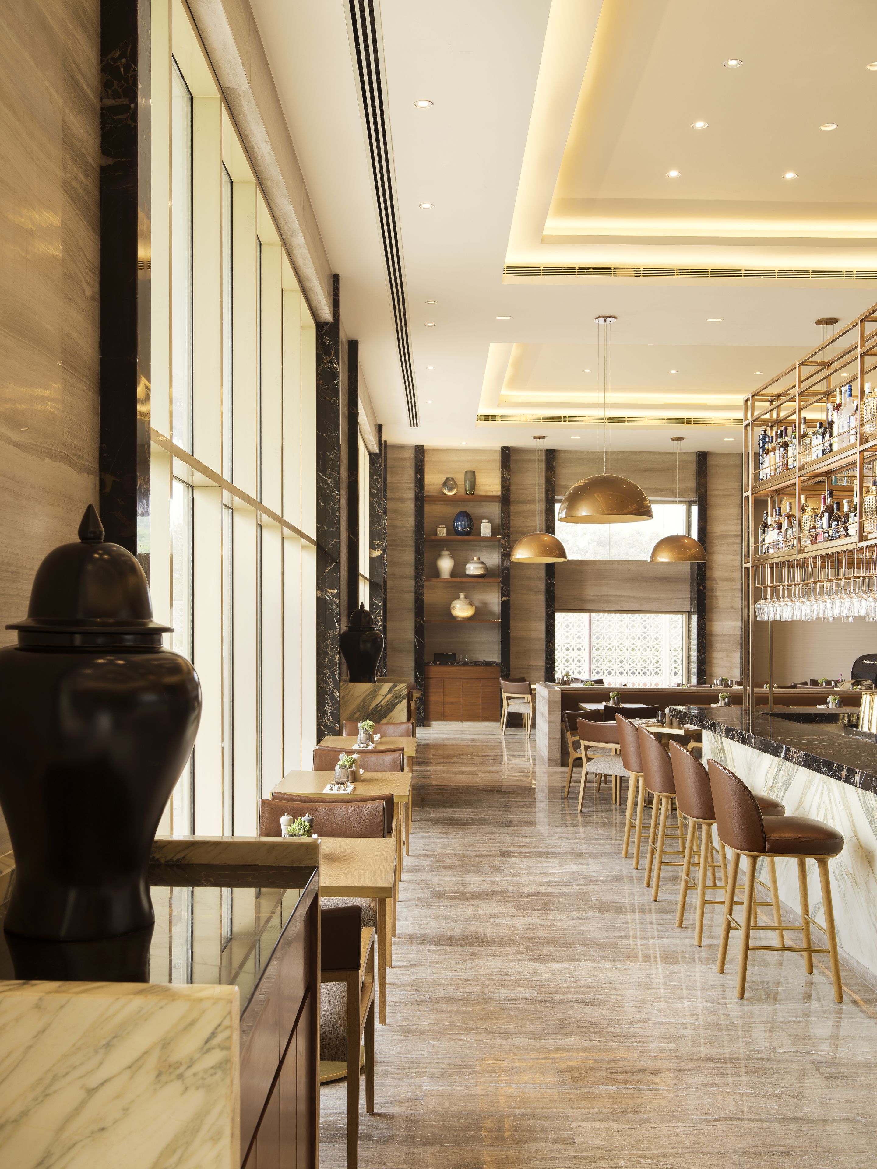 A modern bar area with marble countertops, bar stools, and a wine rack.