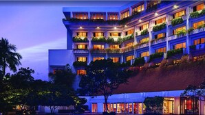 A multi-story hotel with balconies, large windows, and a red-tiled roof.