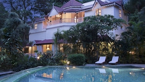 A large, multi-story building with a swimming pool in the foreground. - Taj West End (Bengaluru)