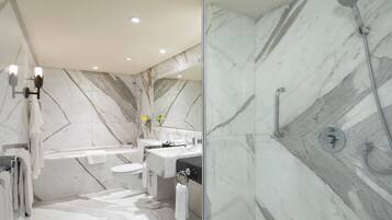 A modern bathroom with a marble floor, a glass-enclosed shower, a bathtub, and a vanity with a mirror.