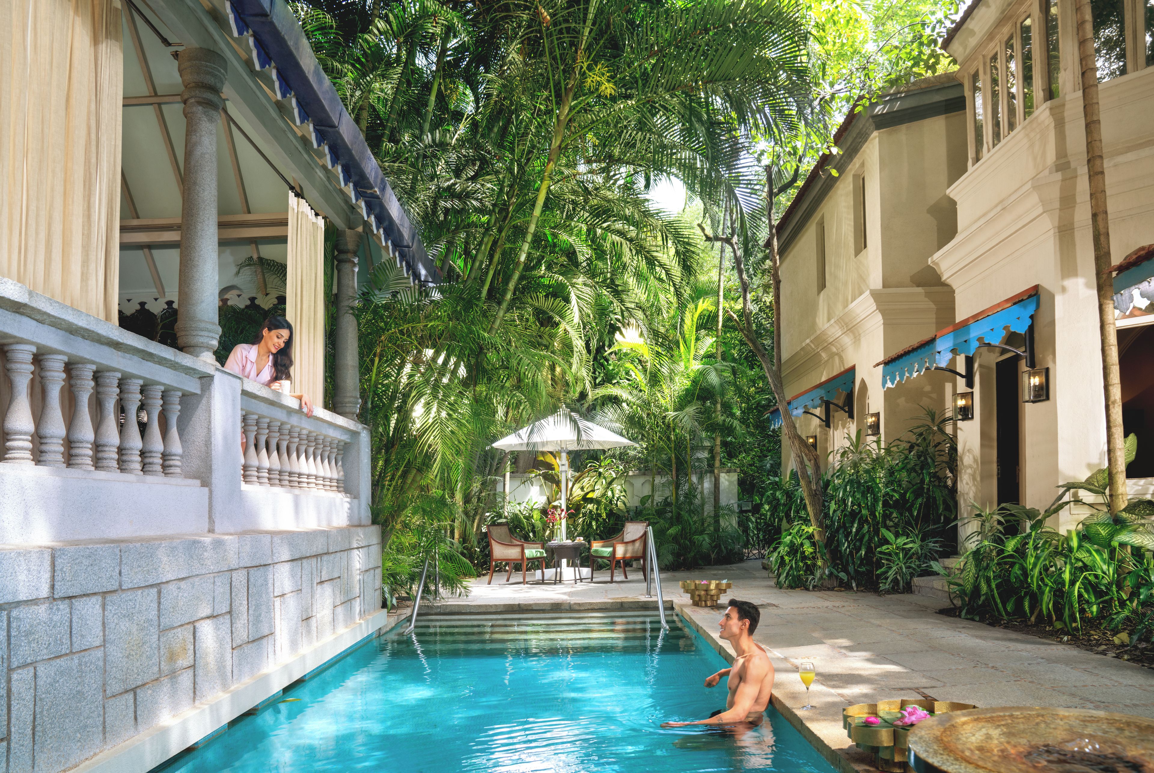 A pool area with a clear water surface, surrounded by lush greenery and architectural elements.