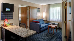A hotel room with a desk, a sofa, a small table, a TV, and a window with curtains. - TownePlace Suites by Marriott Atlanta Buckhead (Atlanta)