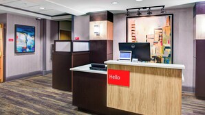 A reception desk with a "Hello" sign, a computer, and a large abstract painting on the wall. - TownePlace Suites by Marriott Atlanta Buckhead (Atlanta)