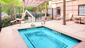 A rectangular swimming pool with a diving board and a safety ladder, surrounded by a brick deck and a metal fence. - TownePlace Suites by Marriott Atlanta Buckhead (Atlanta)