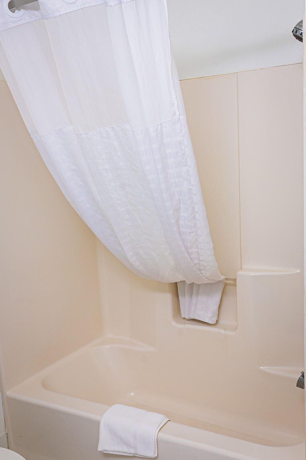 Un baño con una bañera, un cortinón de ducha y una toalla.