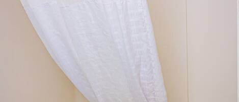 Un baño con una bañera, un cortinón de ducha y una toalla.