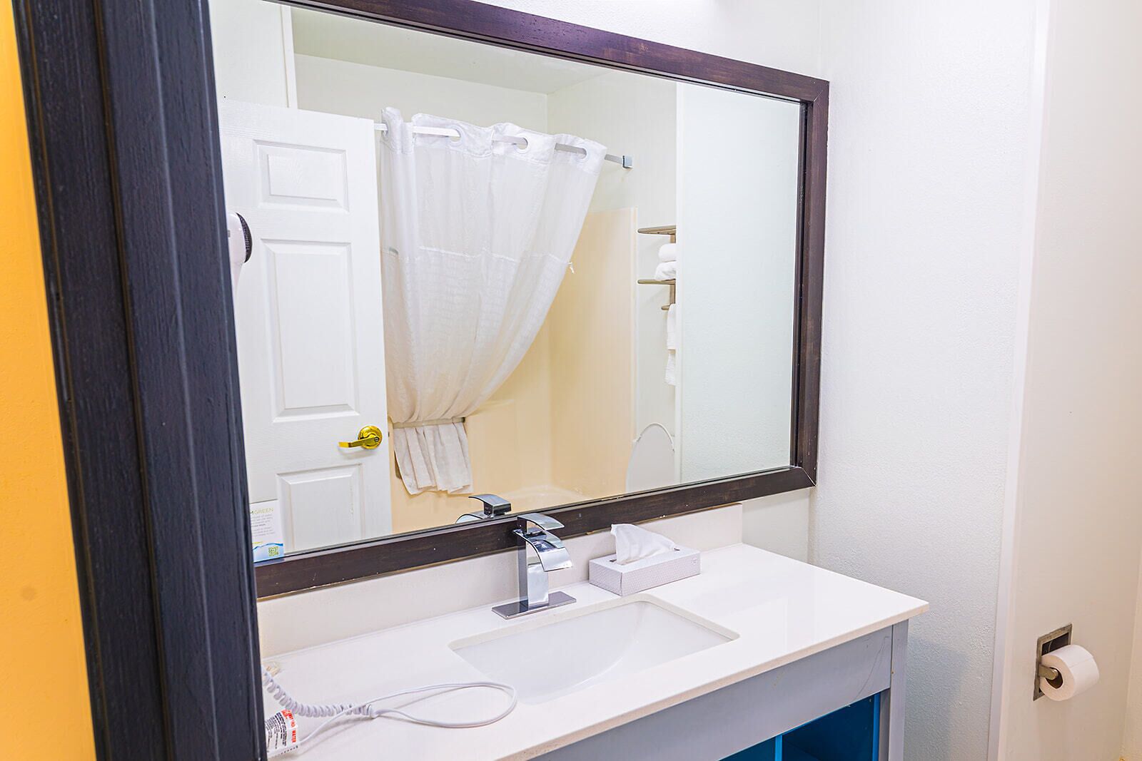 A bathroom with a white sink, a mirror, and a shower curtain.