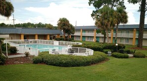 Relax by the hotel's rectangular pool surrounded by lush lawns and trees.