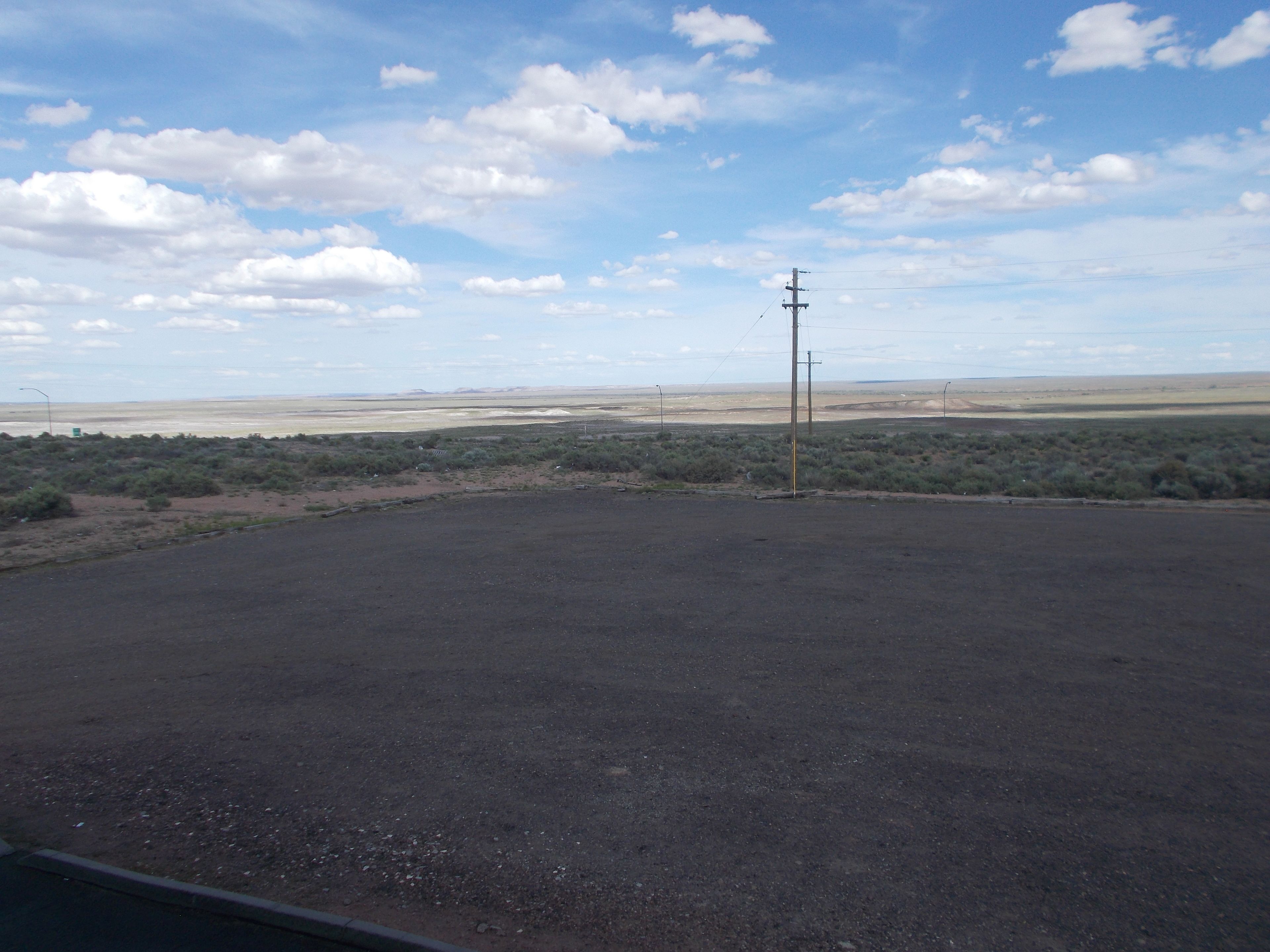 A barren landscape with sparse vegetation and a clear sky.